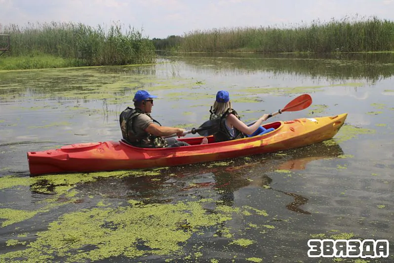 Sporaŭskaje voziera. Liudzi plyvuć na lodcy