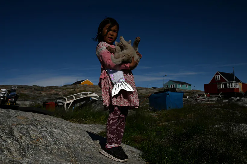 Дзяўчынка са шчанюком у вёсцы Сааттут, Грэнландзія. 9 жніўня 2023 года. Фота: copenhagenphotofestival Дзяўчынка са шчанюком у вёсцы Сааттут, Грэнландзія. 9 жніўня 2023 года. Фота: copenhagenphotofestival